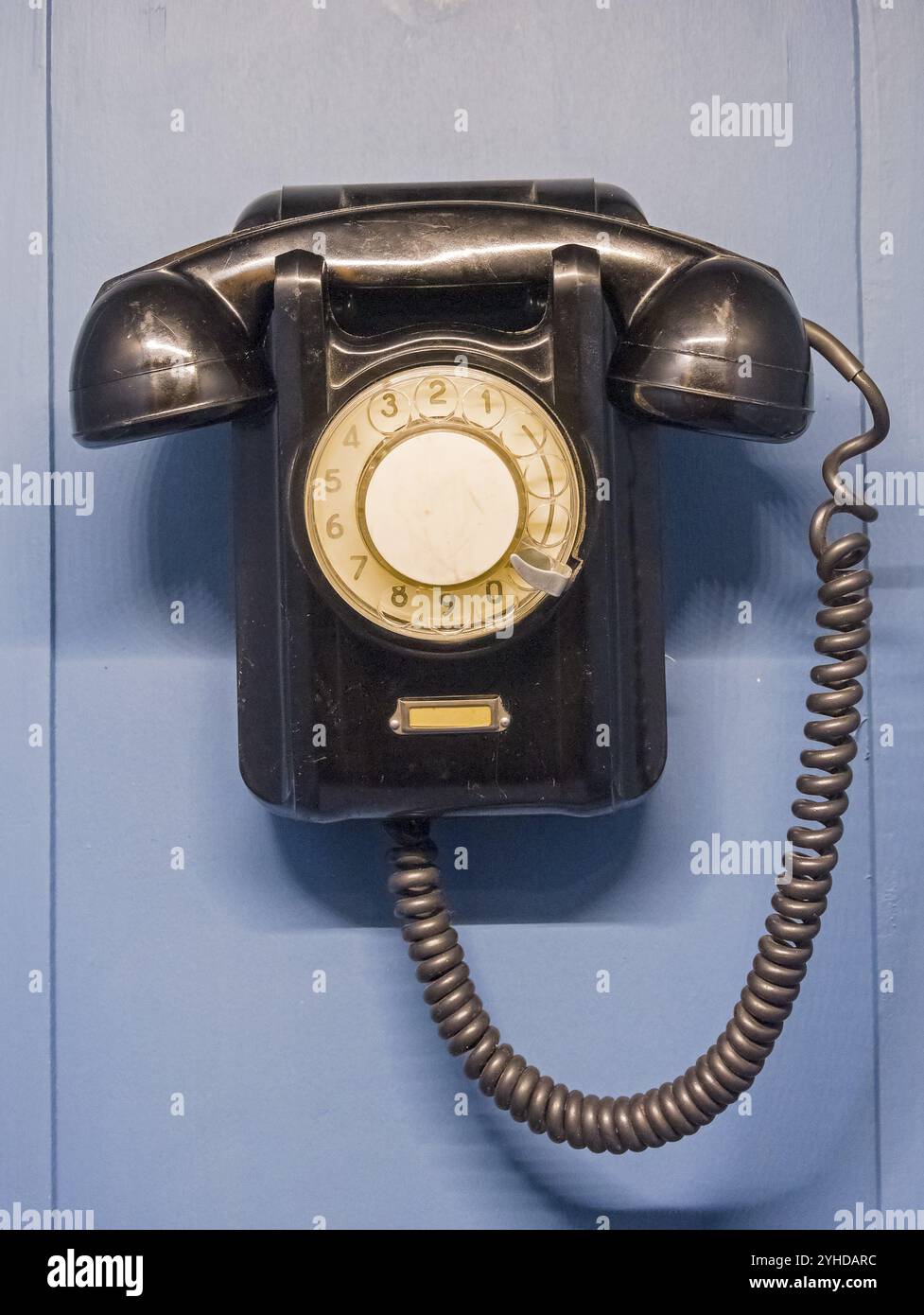 Un vecchio telefono sul muro Foto Stock