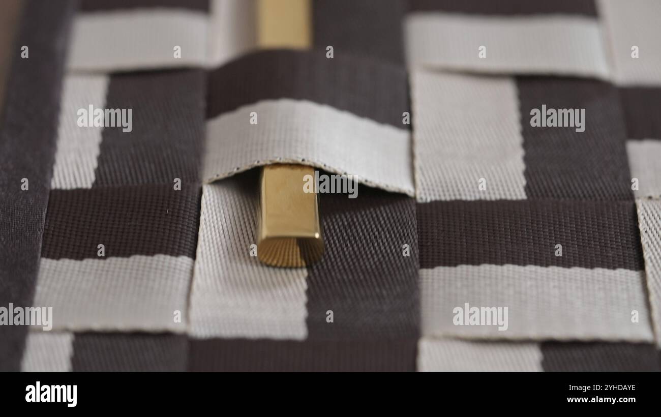 Posate in oro parzialmente visibili con motivo a scacchi marrone e beige Foto Stock