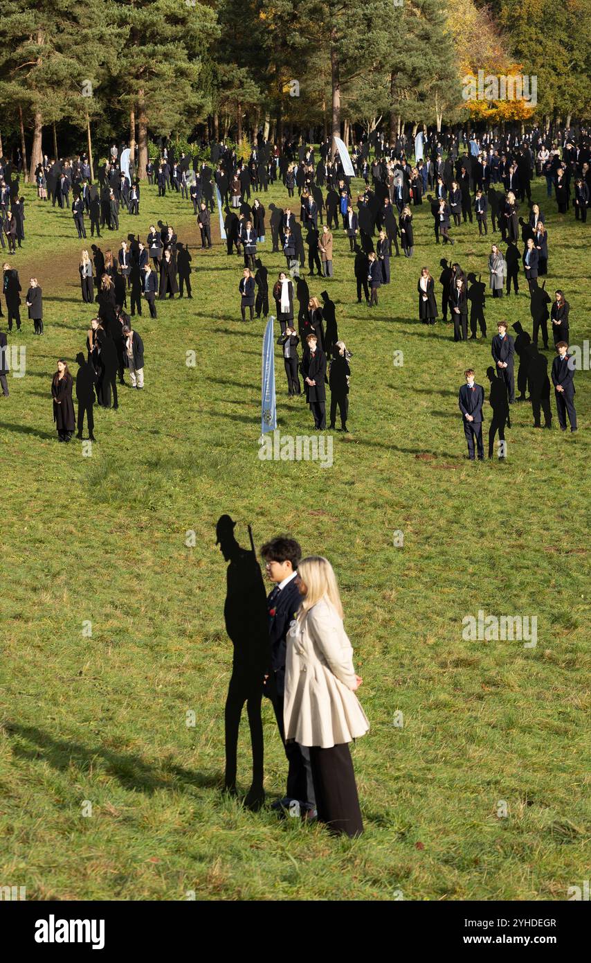 Stowe, Buckinghamshire, Regno Unito. 11 novembre 2024. Gli alunni della Stowe School e i membri del pubblico si riuniscono accanto alle statue metalliche che commemorano i soldati caduti all'2024 11° ora dell'11° giorno del servizio di commemorazione dell'11° mese presso gli Stowe Gardens del National Trust. Standing With Giants è un'opera d'arte commemorativa che rappresenta i 1475 soldati uccisi durante lo sbarco del D-Day il 6 giugno 1944 Credit: Donald Cooper/Alamy Live News Foto Stock