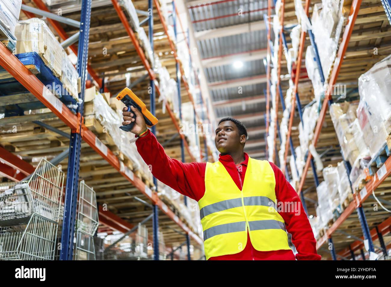 Foto ad angolo ridotto con spazio di copia di un lavoratore latino che esegue la scansione dei prodotti dagli scaffali del magazzino di distribuzione Foto Stock