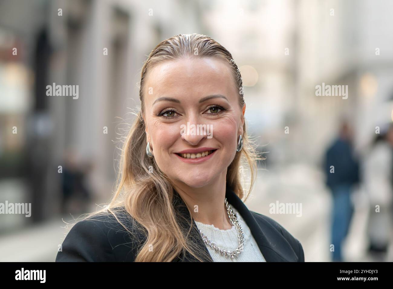 Ritratto estetico di una donna felice di 35-40 anni, con un aspetto europeo, contro un paesaggio urbano. Foto Stock