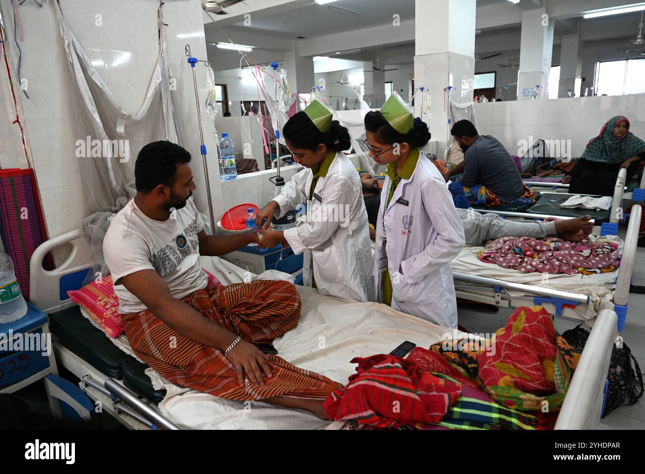 Dacca, Bangladesh. 11 novembre 2024. L'infermiera tratta un paziente coperto di zanzariere affette da febbre dengue riposa all'interno dell'ospedale medico "Shaheed Suhrawardy" di Dhaka, Bangladesh, l'11 novembre 2024. Dal 1° gennaio 2024 all'11 novembre 2024, un totale di 75.142 persone sono state colpite dalla dengue. Almeno 310 persone sono morte nel peggiore focolaio di dengue del Bangladesh mai registrato, hanno detto i funzionari l'11 novembre, mentre gli ospedali sovraccarichi lottano per curare migliaia di pazienti. Crediti: Mamunur Rashid/Alamy Live News Foto Stock