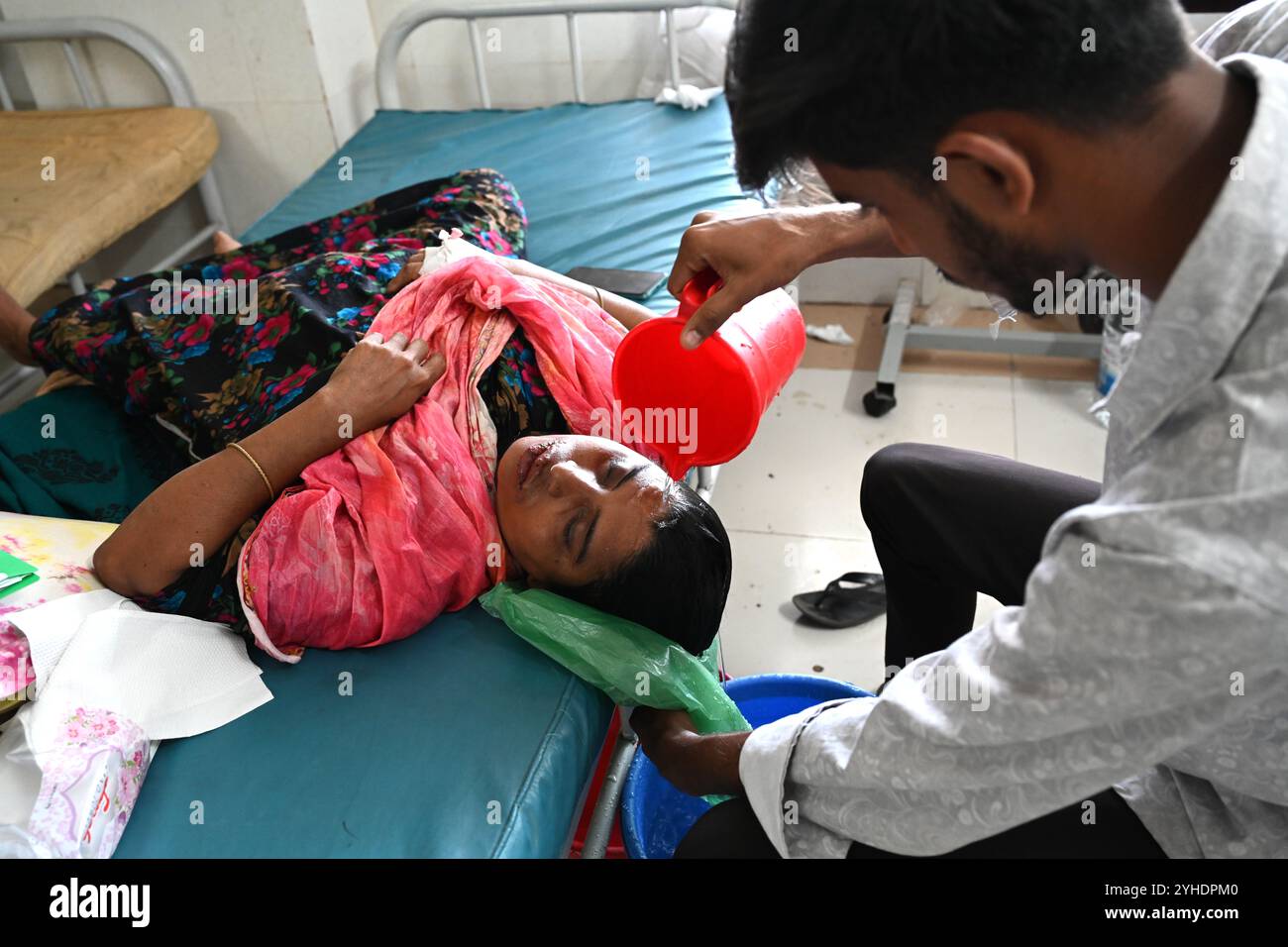 Dacca, Bangladesh. 11 novembre 2024. Un parente versa acqua sulla testa di un paziente affetto da dengue che soffre di febbre dengue riposa all'interno dell'ospedale "Shaheed Suhrawardy" Medical collega di Dhaka, Bangladesh, l'11 novembre 2024. Dal 1° gennaio 2024 all'11 novembre 2024, un totale di 75.142 persone sono state colpite dalla dengue. Almeno 310 persone sono morte nel peggiore focolaio di dengue del Bangladesh mai registrato, hanno detto i funzionari l'11 novembre, mentre gli ospedali sovraccarichi lottano per curare migliaia di pazienti. Crediti: Mamunur Rashid/Alamy Live News Foto Stock