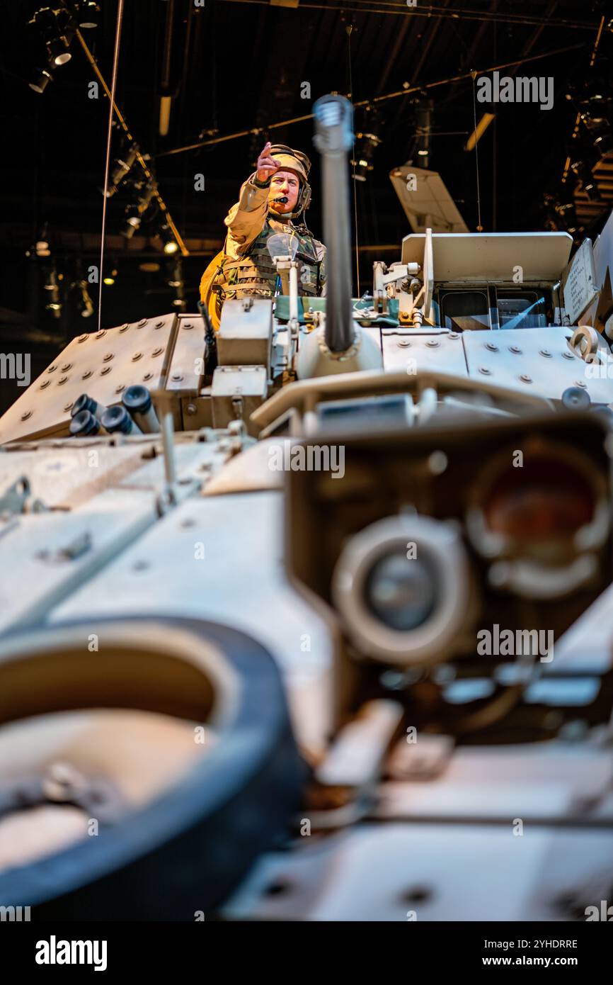 Museo Nazionale del Veicolo da Combattimento Bradley dell'Esercito degli Stati Uniti Fort Belvoir Virginia | FORT BELVOIR, Virginia — Un manichino cannoniere dirige il traffico dalla cupola di un veicolo da combattimento Bradley al Museo Nazionale dell'Esercito degli Stati Uniti, incorniciato attraverso l'ottica e l'hardware delle portelle del veicolo stesso. L'angolo ravvicinato evidenzia i sistemi di puntamento e i pannelli di armatura applicata dell'M2A3. La posa ricrea quella di un comandante dell'equipaggio Bradley che segnala sul campo durante le operazioni nel deserto. Foto Stock