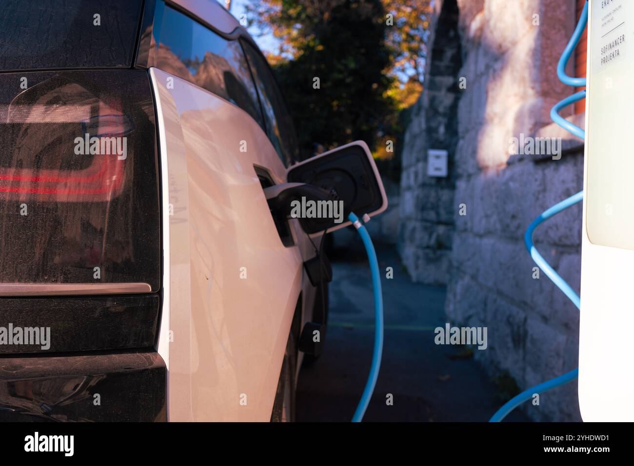 Ricarica del veicolo elettrico presso una stazione Foto Stock