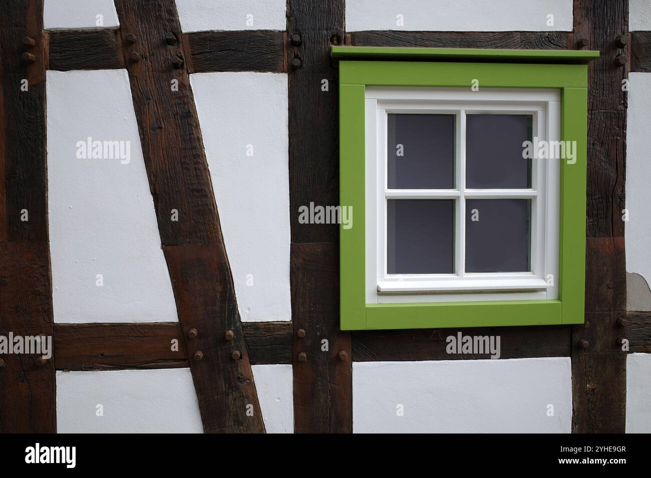 Parete bianca di una casa per metà in legno con una cornice verde della finestra Foto Stock