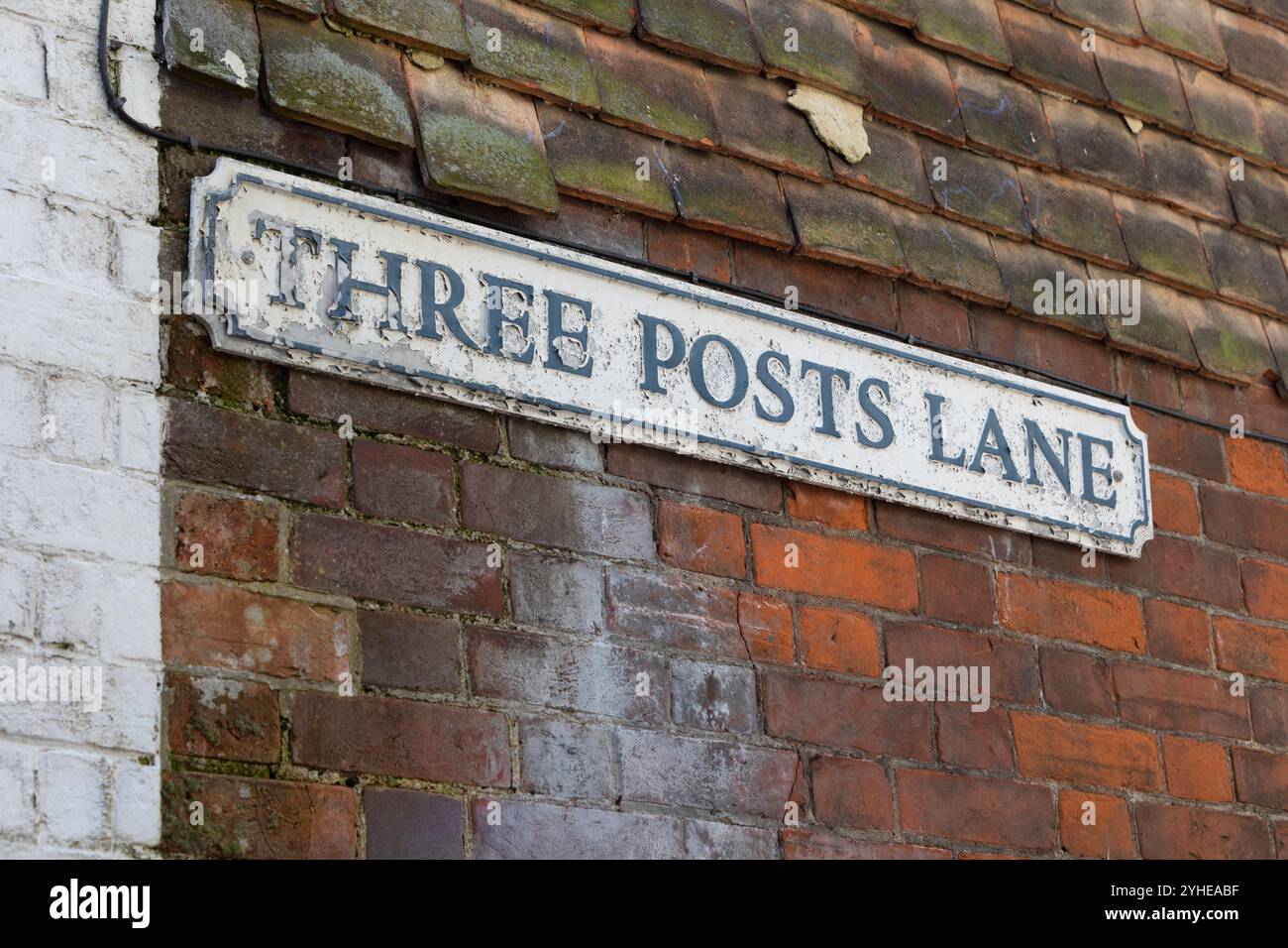 Un vecchio cartello usurato con vernice sbucciante per Three Posts Lane a Hythe, nel Kent. Foto Stock