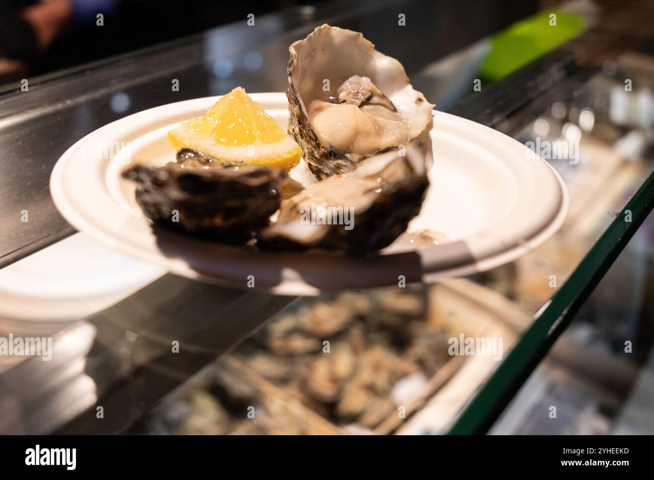 Un piatto di pesce fresco servito con limone che offre autentiche esperienze culinarie. Foto Stock
