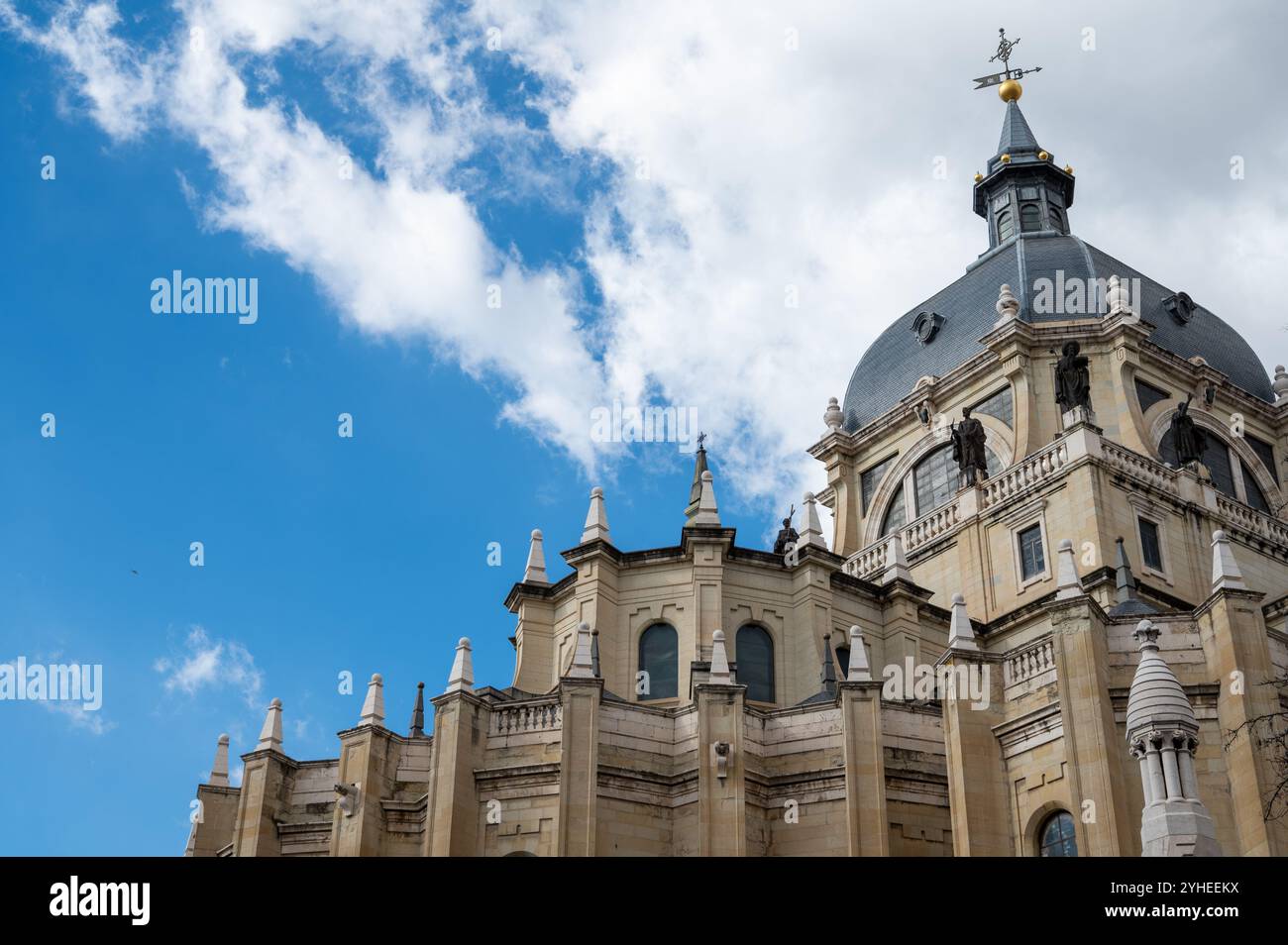 Cattedrale di Almudena in Spagna con nuvole e goccia nera di cielo blu Foto Stock