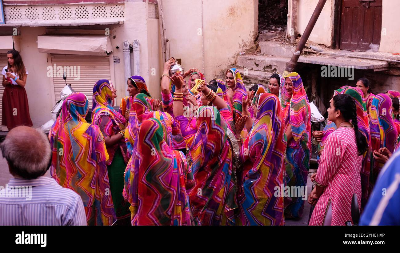 La festa nuziale in occasione di un matrimonio danzerà per le strade di Udaipur, come la gente del posto e i turisti osservano Foto Stock