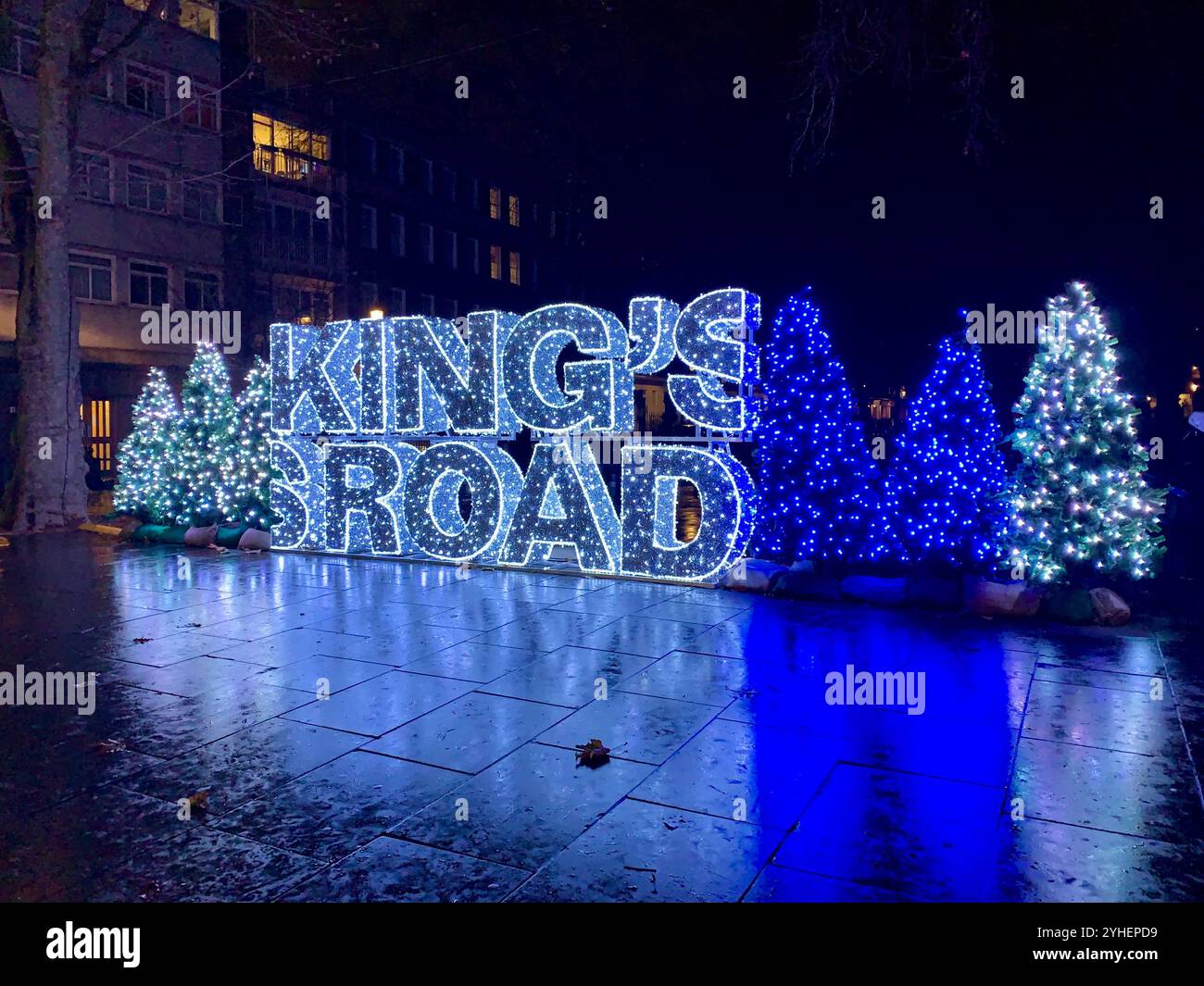 King's Road a Chelsea, Londra. Luci natalizie che mostrano grandi lettere che scrivono King's Road in blu con alberi di Natale anche in blu Foto Stock