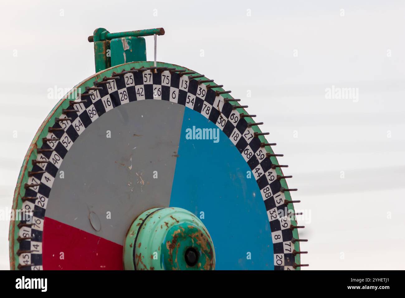 Un primo piano di una ruota a premi di carnevale d'epoca con sezioni numerate, con vivaci colori rosso e blu. Ideale per concetti di caso, divertimento e no Foto Stock