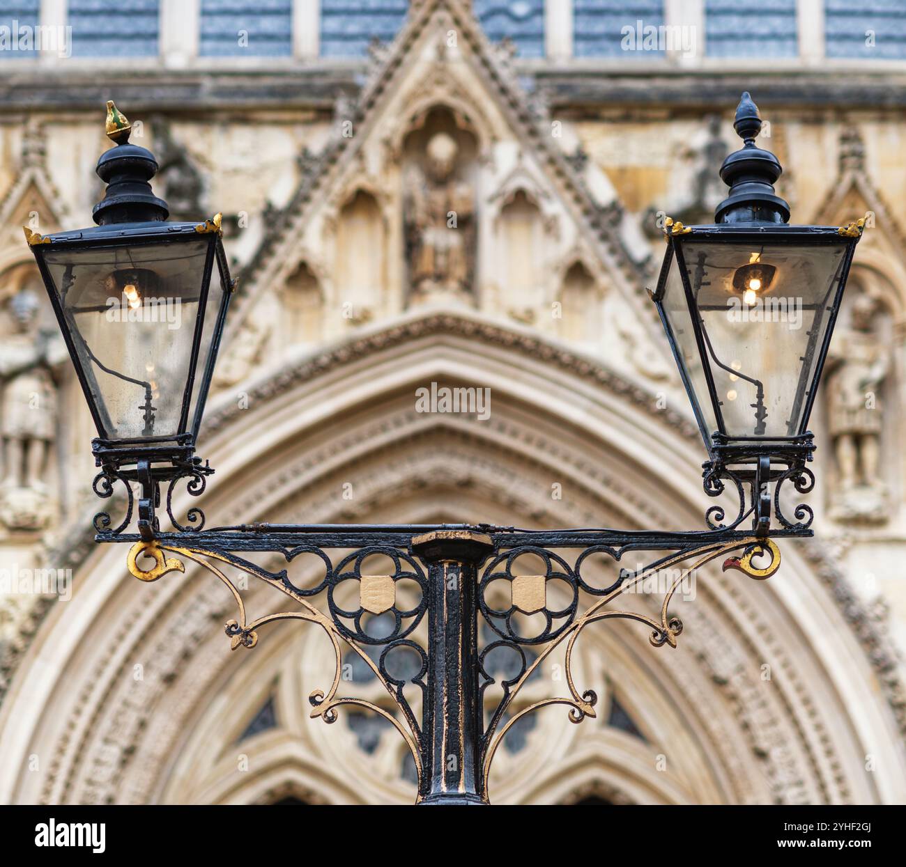 Lampade ornate in ferro battuto si trovano di fronte alla facciata delle torri di York Minster che si affacciano ad ovest. Le statuette sono negli inserti dell'elaborata ar gotica Foto Stock