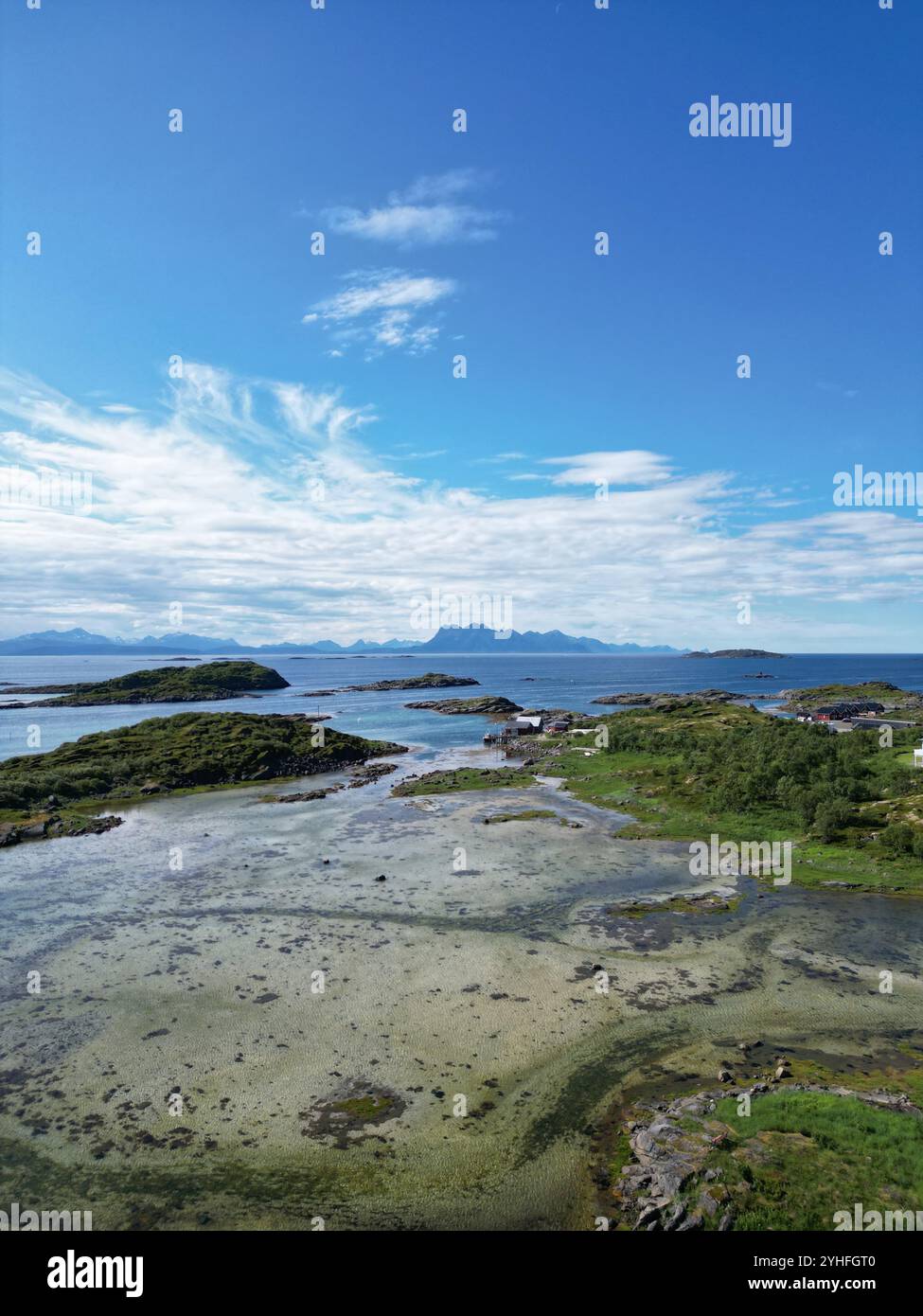 Tiro verticale con un drone, mezzo oceano marino con isole e spiaggia, metà cielo con nuvole leggere e sole, bassa marea, vedi attraverso l'acqua Foto Stock