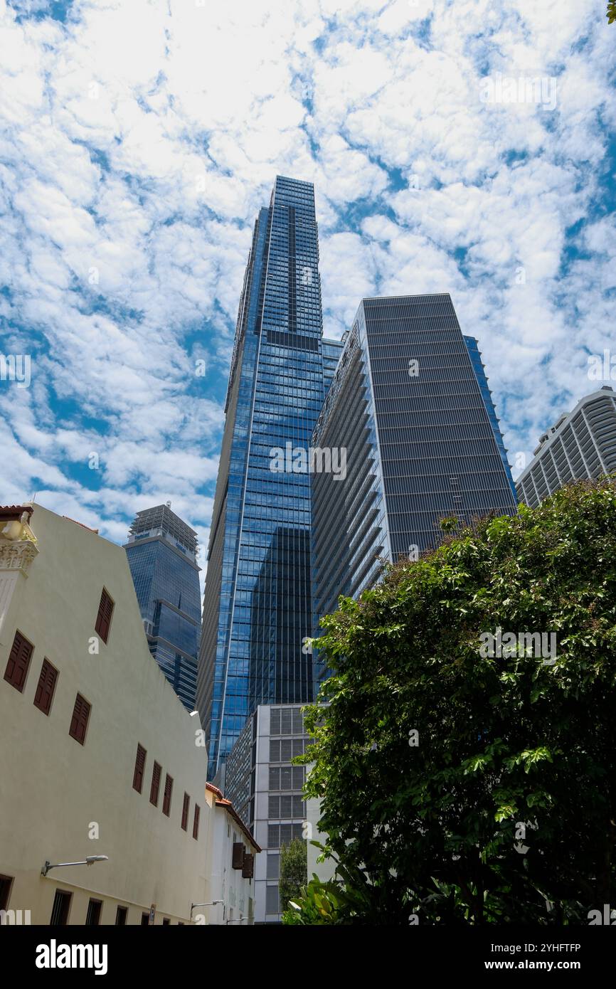 Una vista della Guoco Tower Singapore che sminuisce le piccole botteghe e mostra il contrasto dell'architettura all'interno della città. Foto Stock