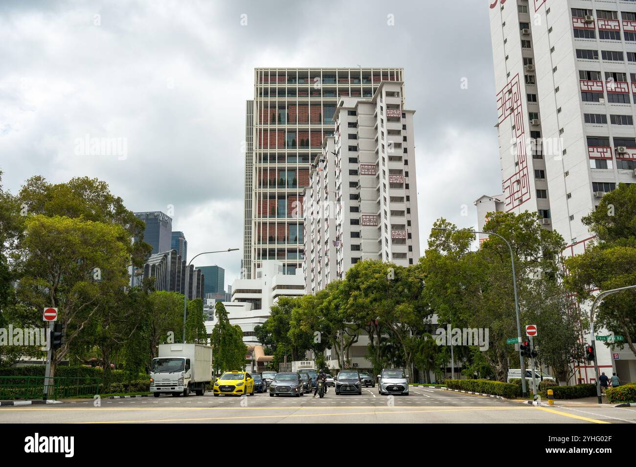 Singapore Chin Swee Road e l'incrocio tra Upper Cross Street e l'alloggio Block 51 e State Court Towers accanto alla strada urbana alberata. Foto Stock