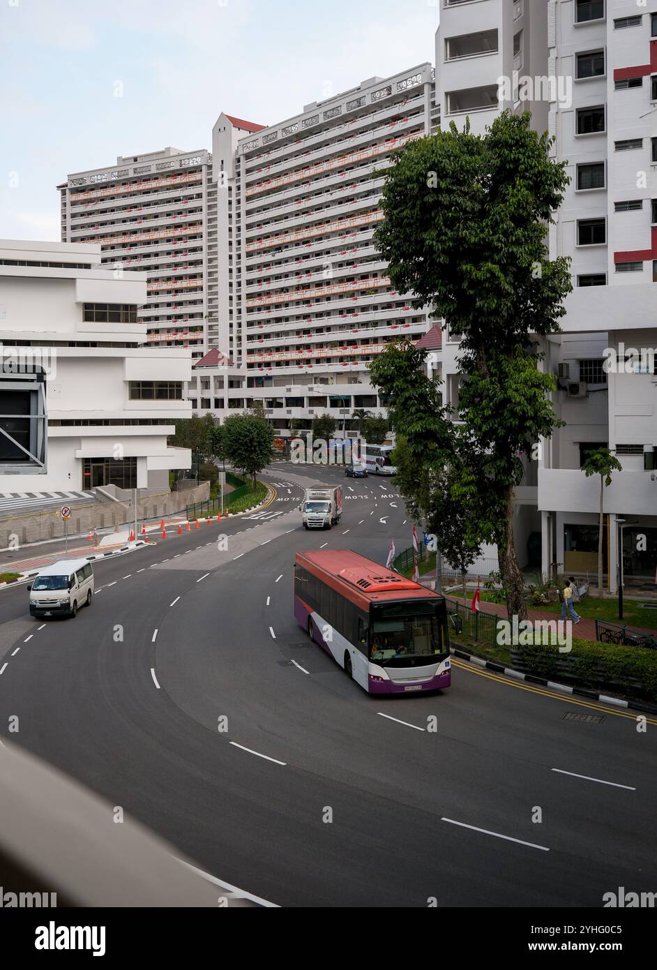 Area centrale di Singapore Asia che mostra l'isolato 34 del complesso residenziale e commerciale con la strada curva e un autobus in primo piano. Foto Stock