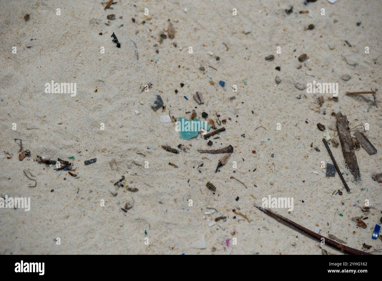 Microplastica lavata sulla spiaggia di St Johns Island Singapore. Gli ecosistemi acquatici sono influenzati dalla plastica monouso che entra negli oceani del mondo Foto Stock