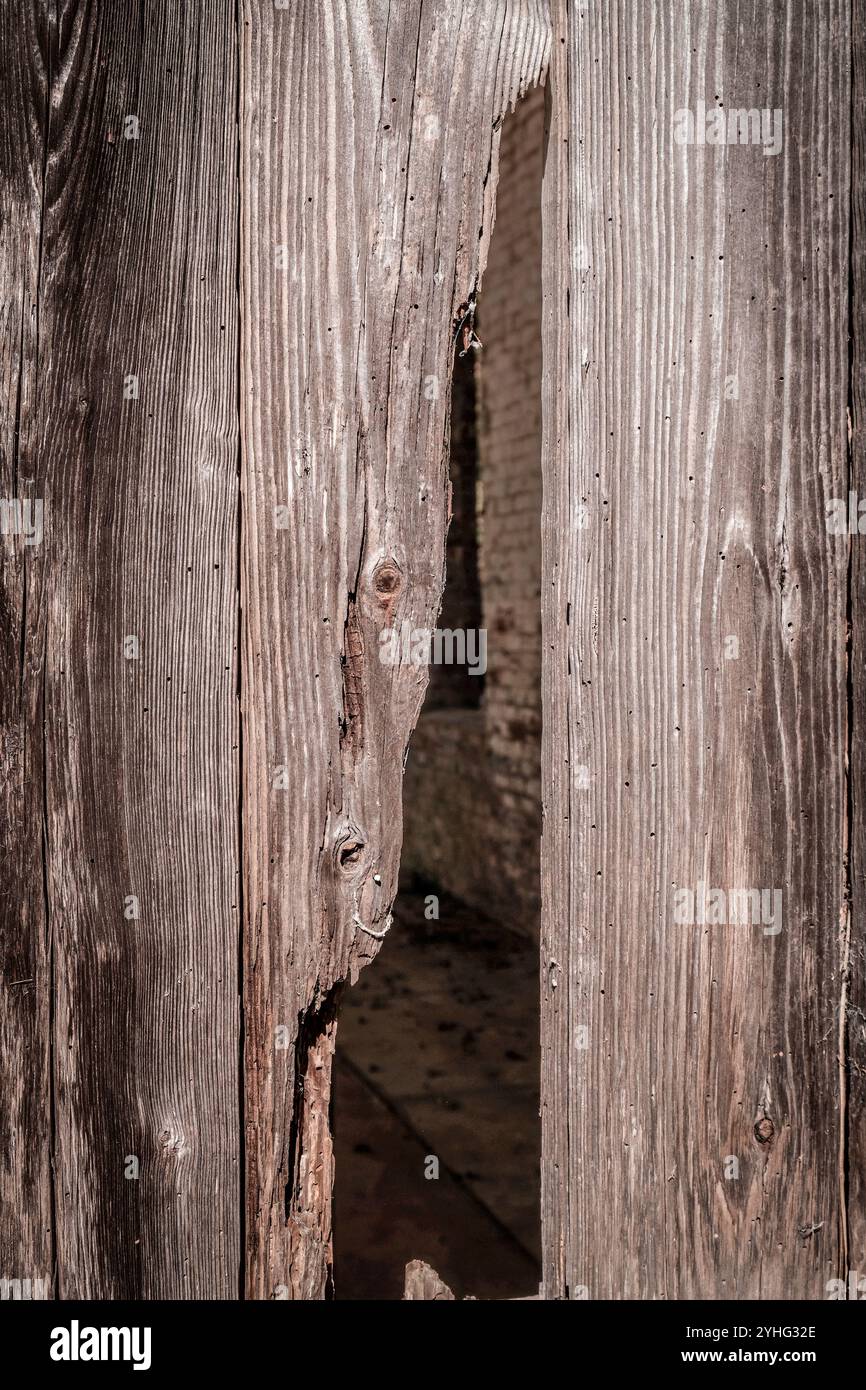 L'otturatore in legno incrinato rivela la vecchia parete in mattoni Foto Stock L'otturatore in legno incrinato rivela la vecchia parete in mattoni Foto Stock