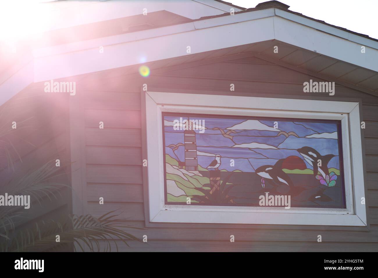 Fotografia di un dipinto di vetro colorato di orche che saltano nell'acqua Foto Stock
