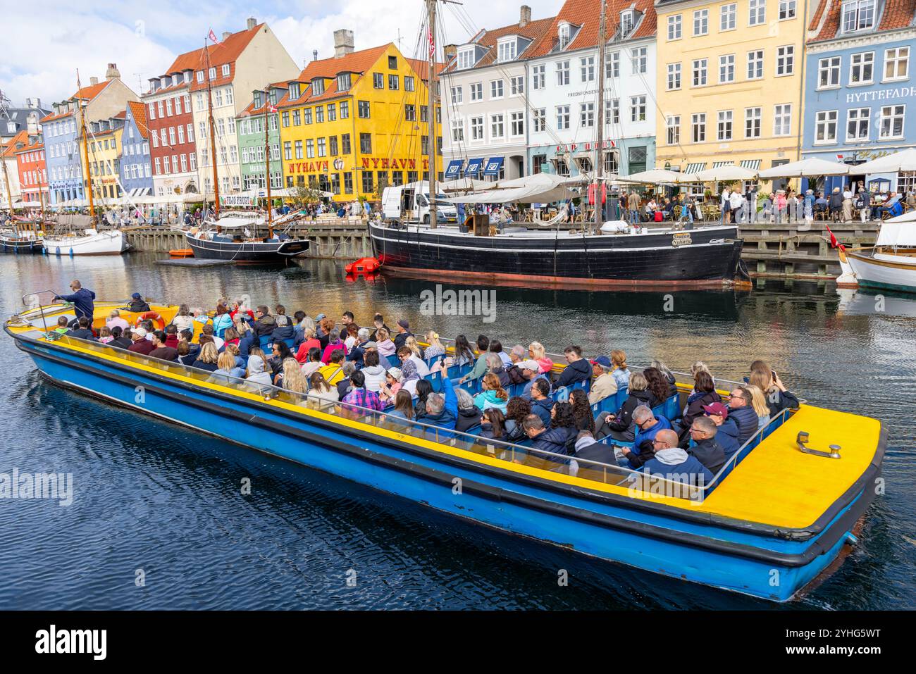 Copenhagen, persone in un tour in barca dei canali lungo il canale Nyhavn, oltre le case colorate del XVII secolo e i ristoranti in questa zona, Danimarca, 2024 Foto Stock