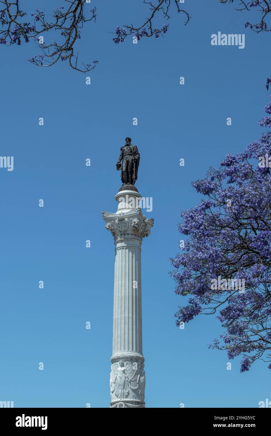 Monumento del re Don Pedro IV in Piazza Rossio, centrale e vivace piazza di Lisbona, con pavimentazione ondulata nella città di Lisbona, capitale del Portogallo, in Europa Foto Stock