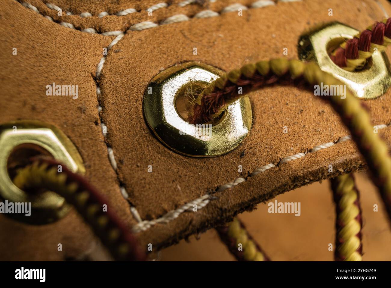 Primo piano dettagliato di lacci delle scarpe e occhielli che mettono in risalto la maestria artigianale e la consistenza in uno sfondo caldo Foto Stock