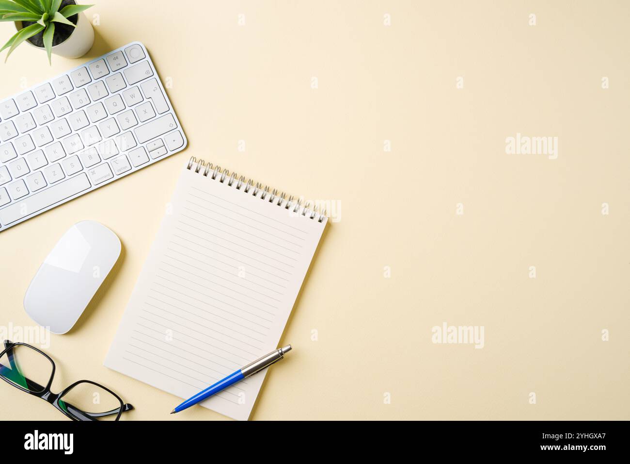 Scrivania da ufficio con tastiera per computer, mouse, occhiali, notebook e penna. Vista superiore con spazio di copia. Posizione piatta Foto Stock