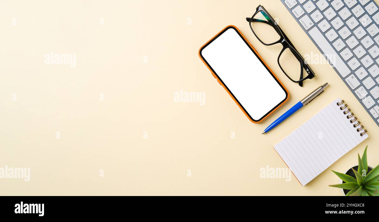 Scrivania da ufficio con tastiera per computer, mouse, smartphone, notebook e penna. Vista superiore con spazio di copia. Posizione piatta Foto Stock