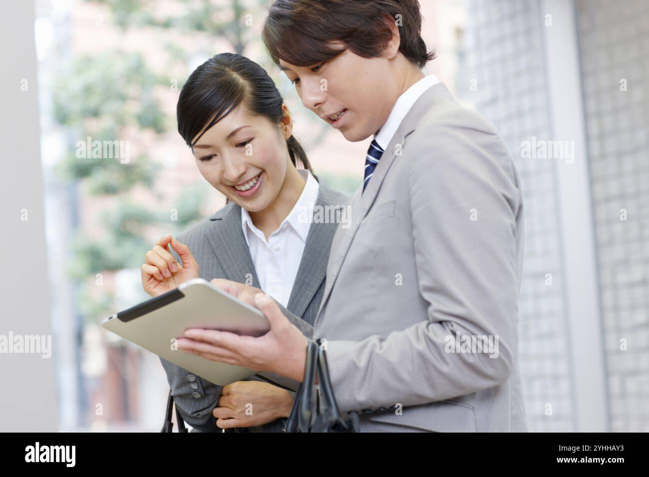 Uomo d'affari e donna che guardano un tablet Foto Stock