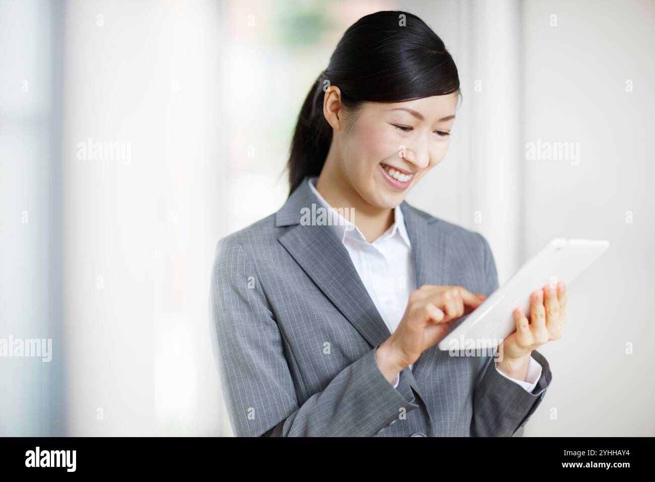 Donna in costume che cerca su un tablet Foto Stock