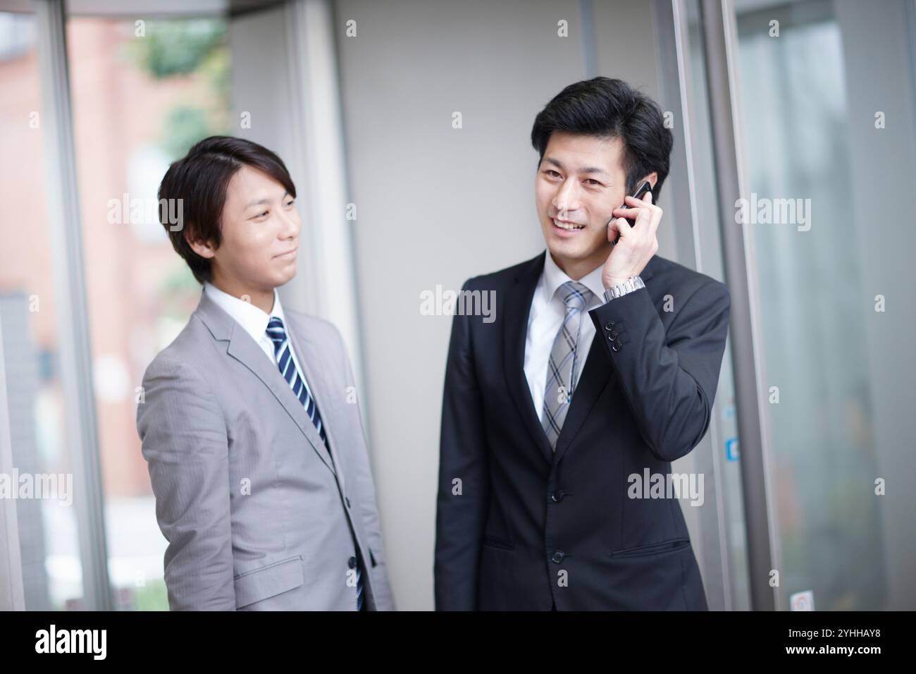 Uomo d'affari e collega che fa una telefonata Foto Stock