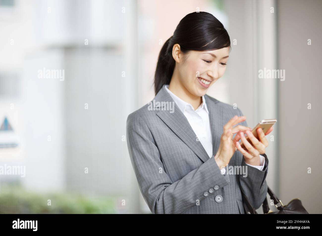 Donna in tuta che guarda lo smartphone Foto Stock