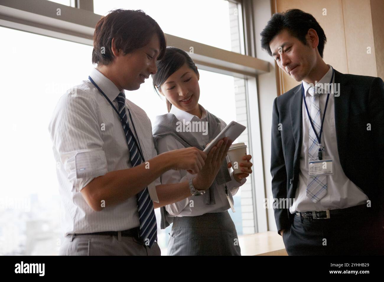 Uomo d'affari e collega che parlano alla finestra Foto Stock