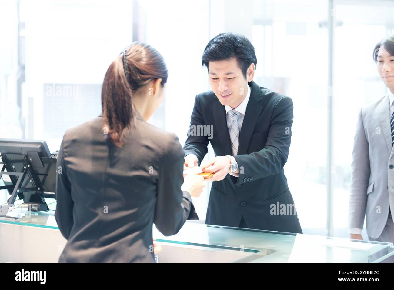 L'addetto alla reception riceve i biglietti da visita alla reception Foto Stock