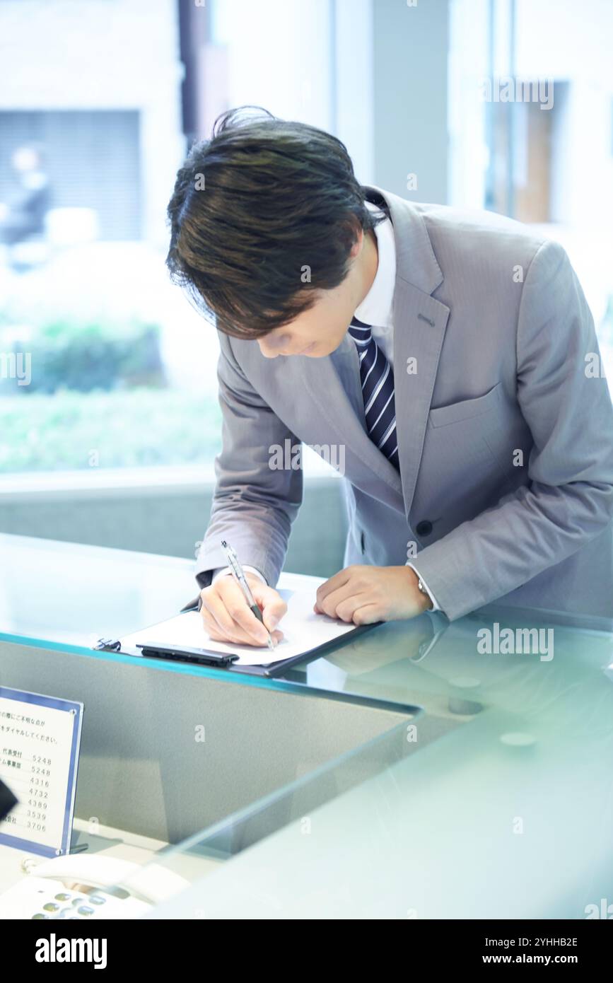 Uomo d'affari presso la reception Foto Stock