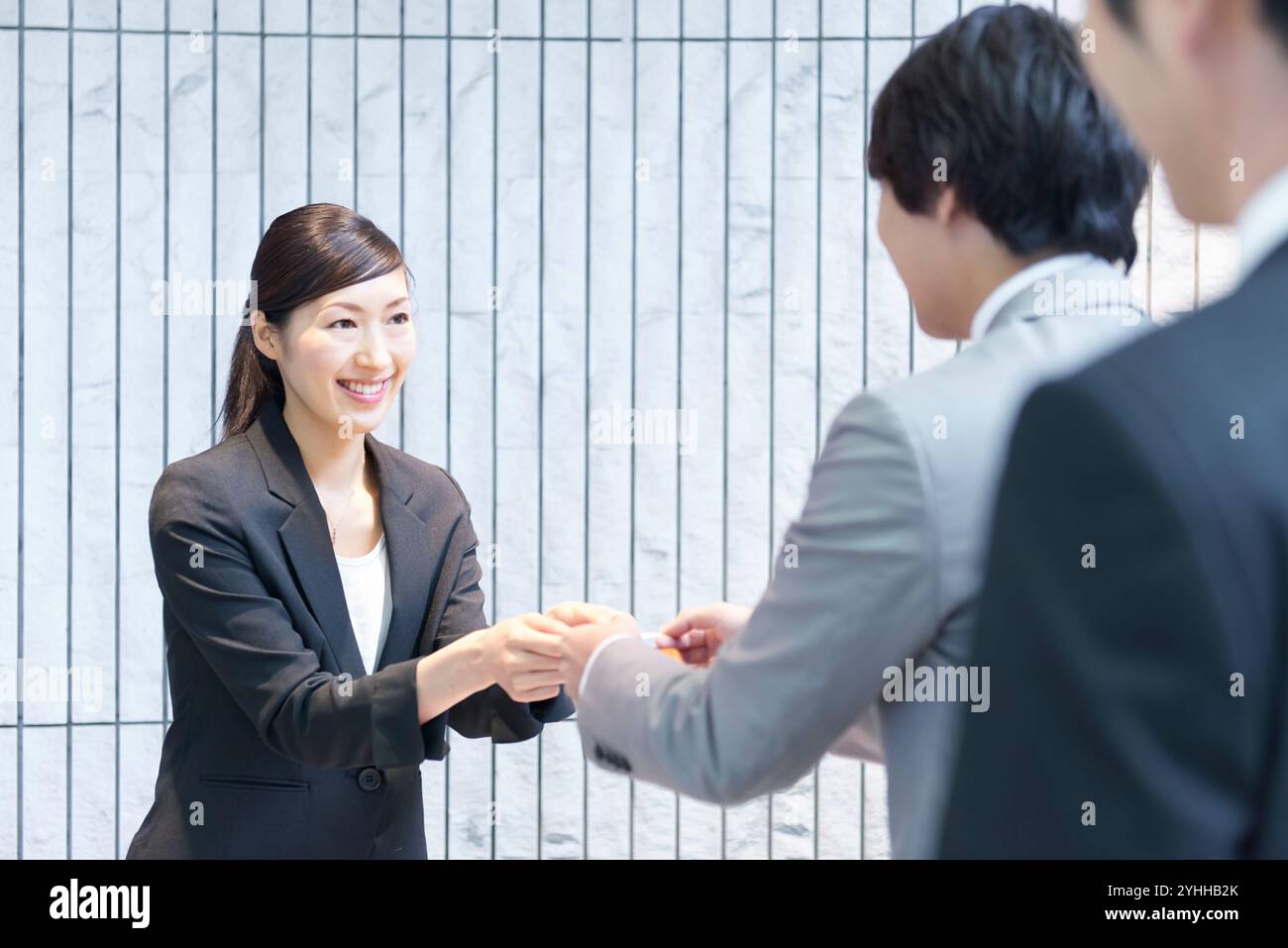 Un uomo d'affari si scambia i biglietti da visita alla reception Foto Stock