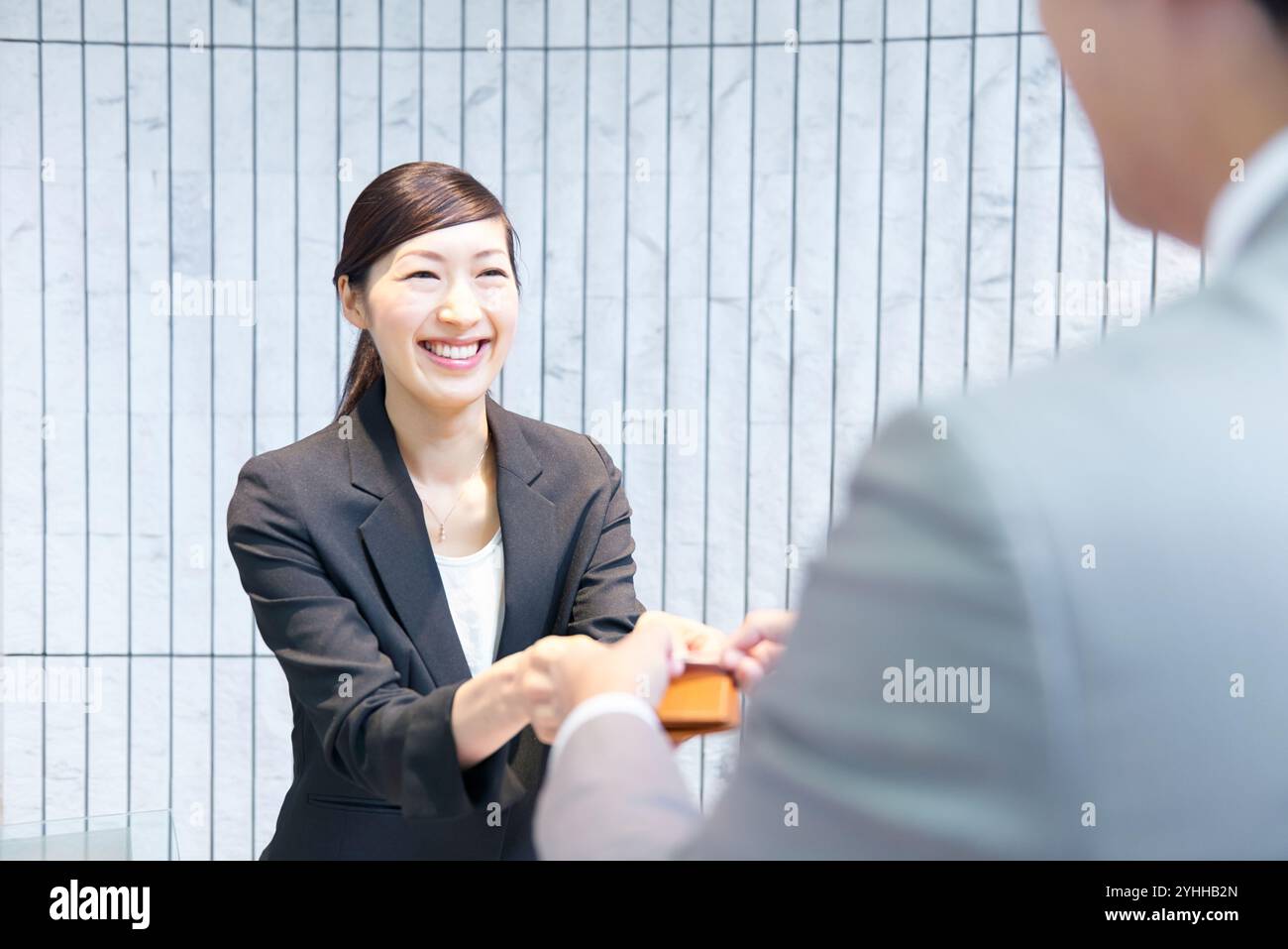Donna alla reception che si scambia i biglietti da visita Foto Stock