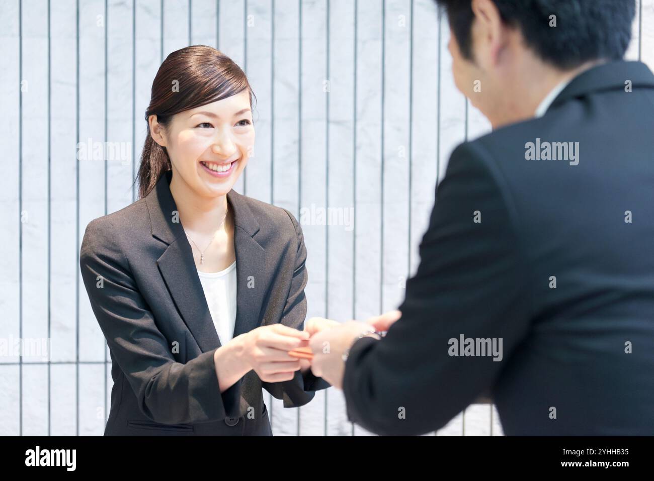 L'addetto alla reception riceve i biglietti da visita alla reception Foto Stock
