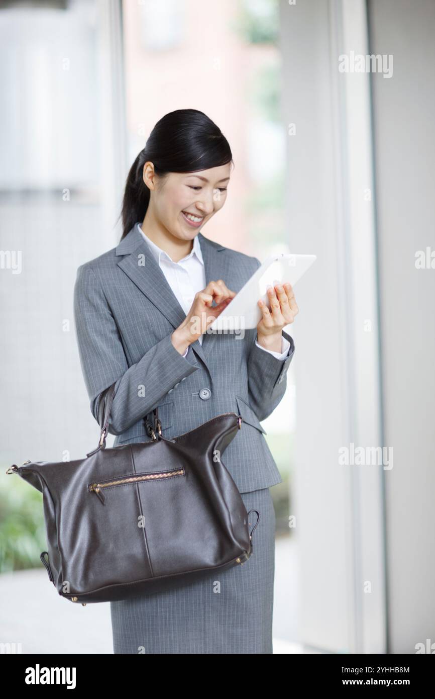 Donna in costume che cerca su un tablet Foto Stock