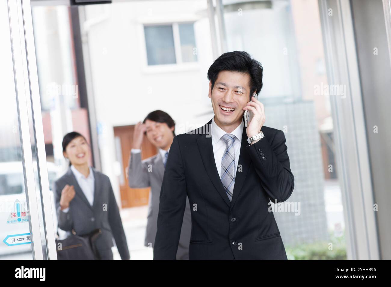Uomo d'affari e collega che fa una telefonata Foto Stock