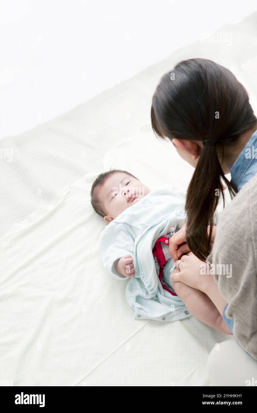 Mamma e bambino che cambiano pannolino Foto Stock