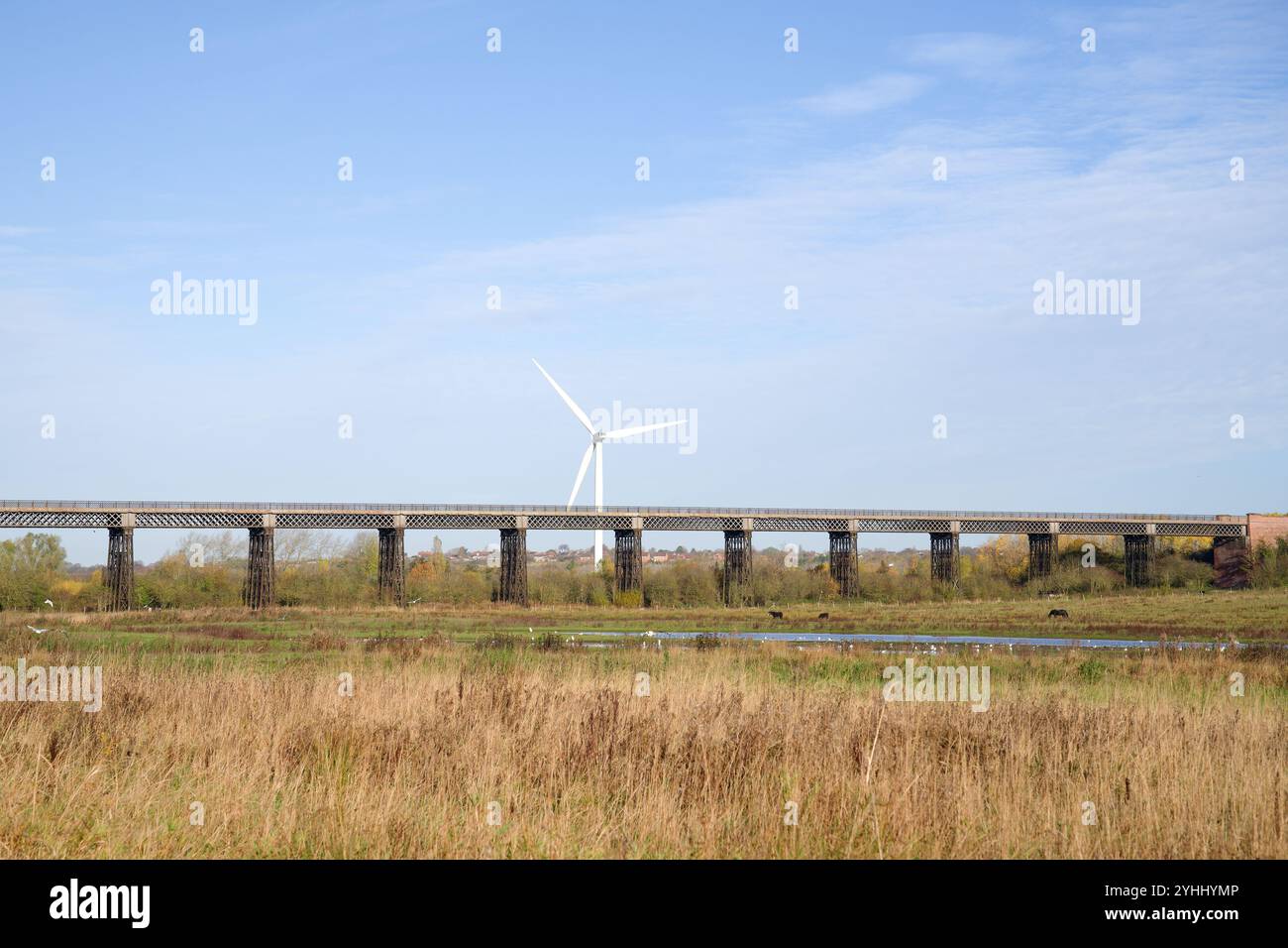 Turbina eolica accanto a un vecchio viadotto Foto Stock