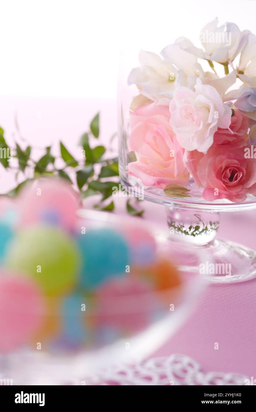 Colorate palline di caramelle e fiori in un vaso di vetro Foto Stock