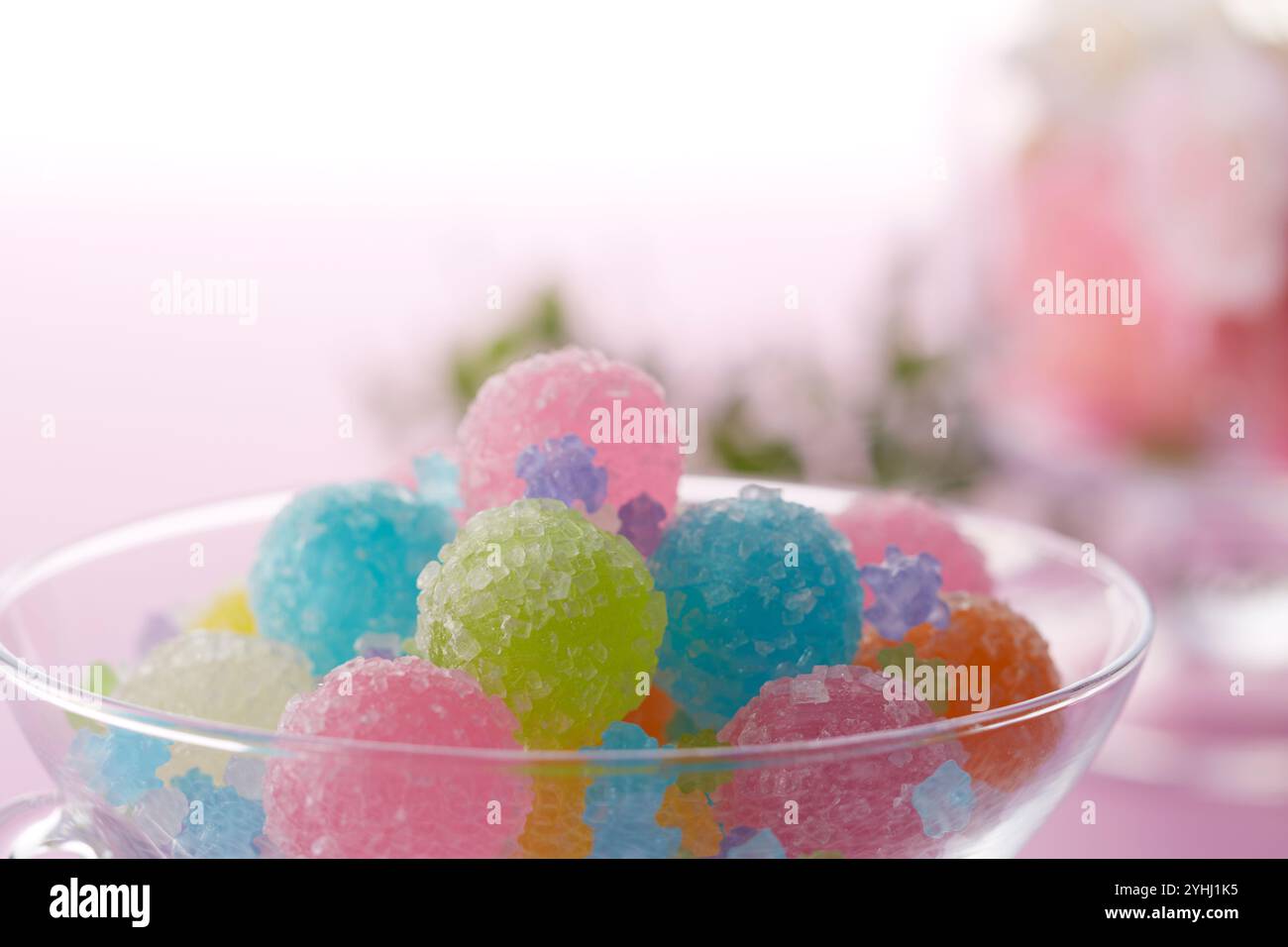 Colorate palline di caramelle e fiori in un vaso di vetro Foto Stock