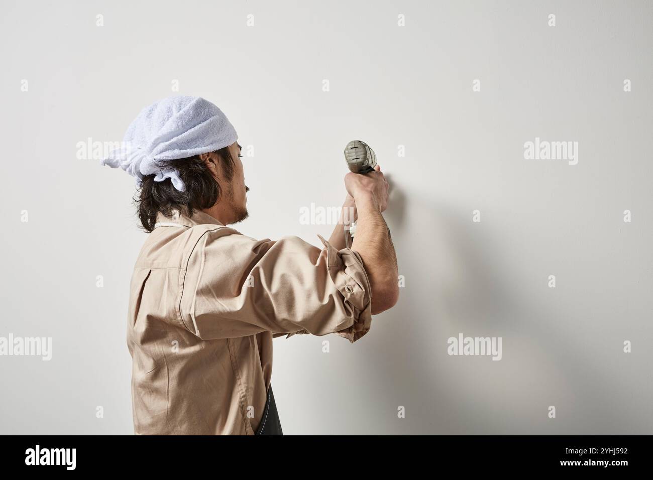 Uomo che utilizza un avvitatore a percussione Foto Stock