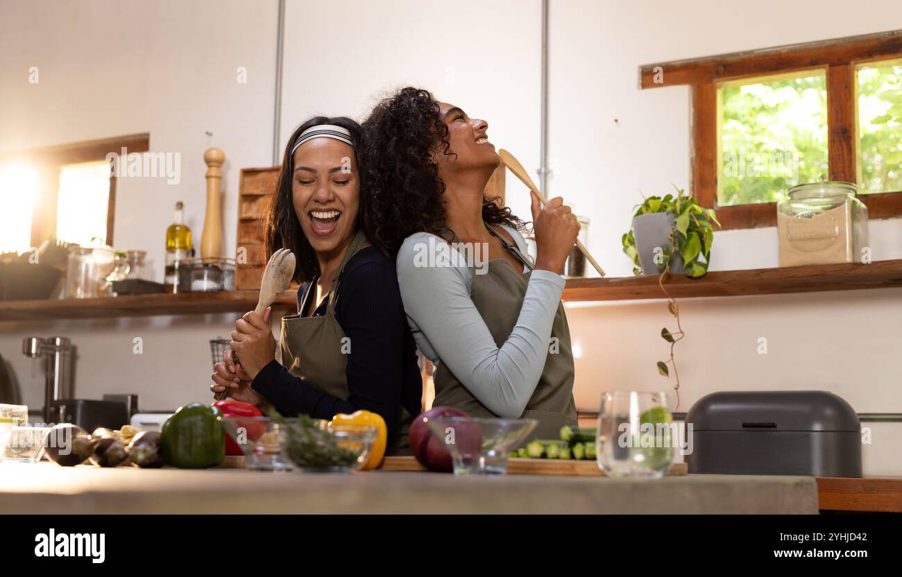 Gioiose amiche multirazziali in cucina cucinando insieme per la festa del Ringraziamento, a casa Foto Stock