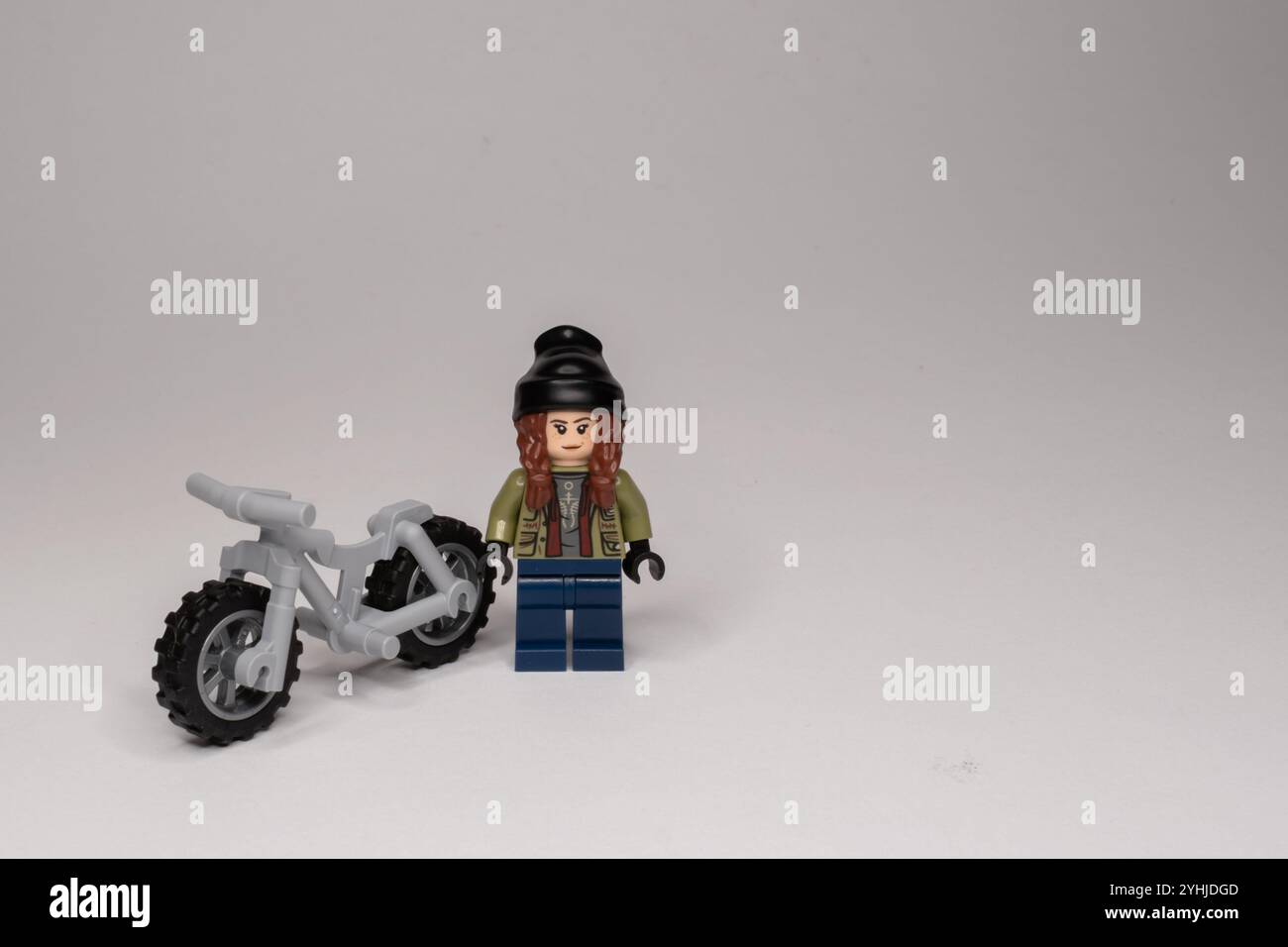 Ragazza LEGO con una bici su uno sfondo luminoso con spazio per le copie Foto Stock