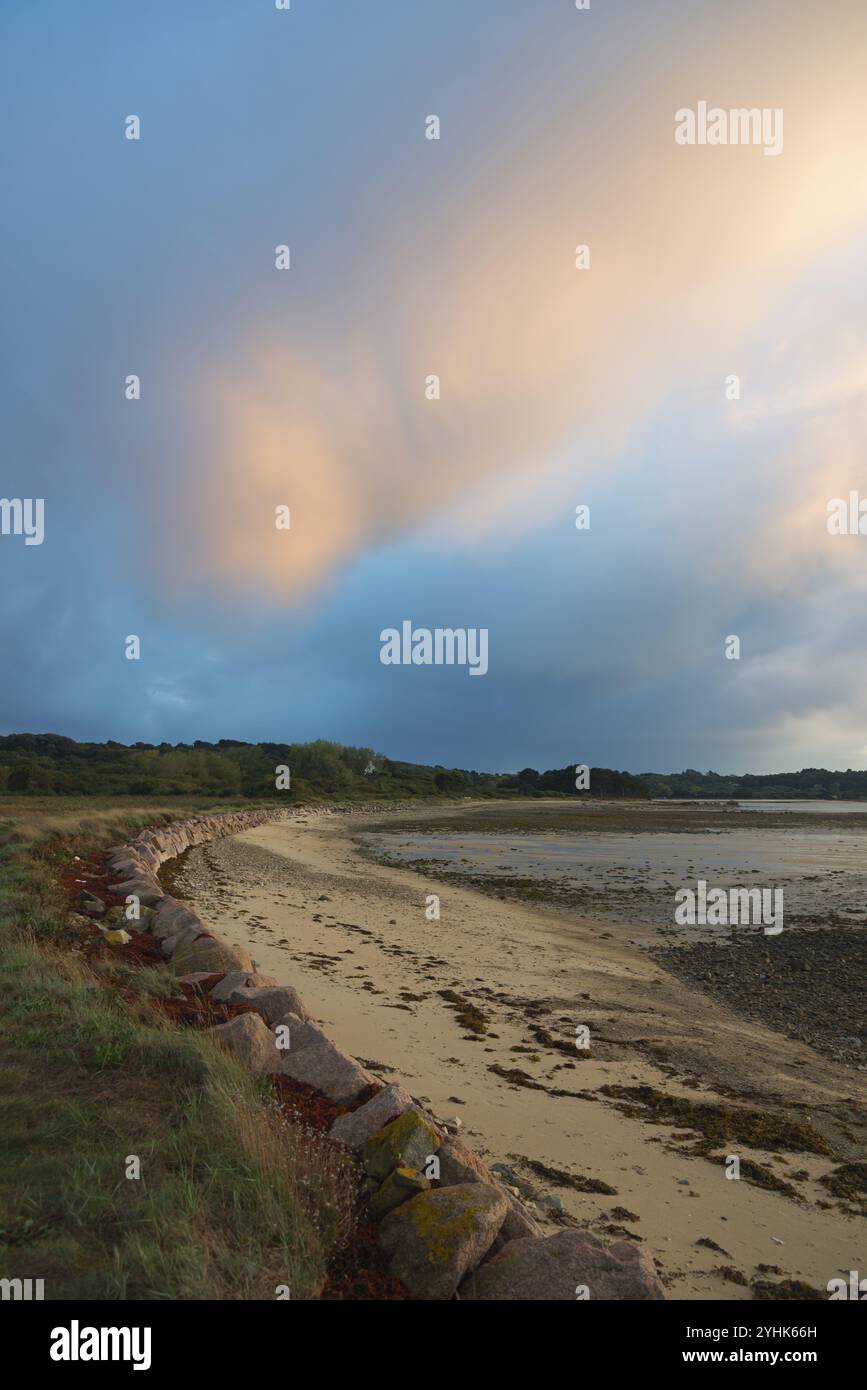 Sentiero costiero lungo la spiaggia al tramonto con morbide nuvole nel cielo, Plage de Raluzet, Plougrescant, Cotes-d'Armor, Manica, Brittany, Francia, E. Foto Stock