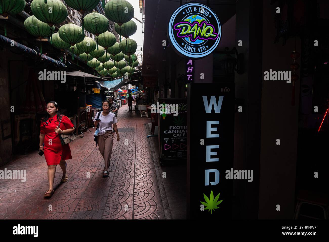 I pedoni passano davanti a un negozio di cannabis a Chinatown, Bangkok. Foto Stock